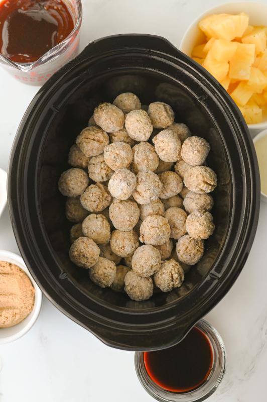 adding meatballs to the slow cooker