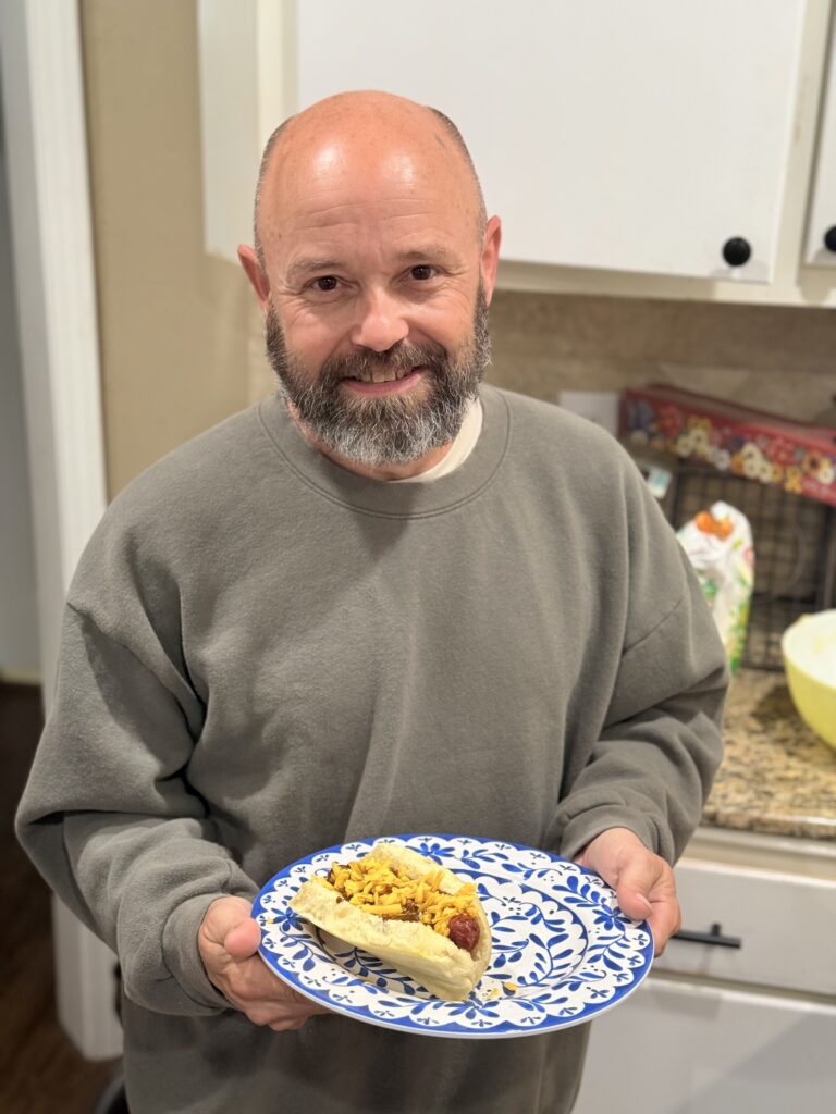daniel holding hotdog on a plate