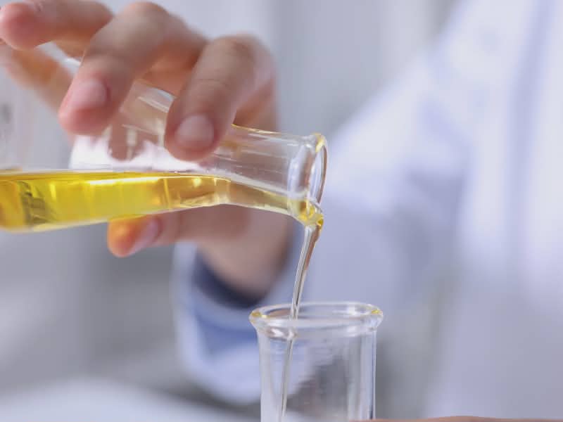 scientist pouring liquid in beakers
