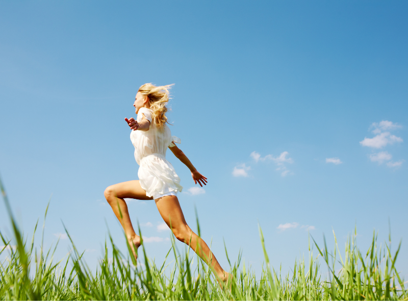 girl running through grass showing energy. Parasitic infections can make you lose energy