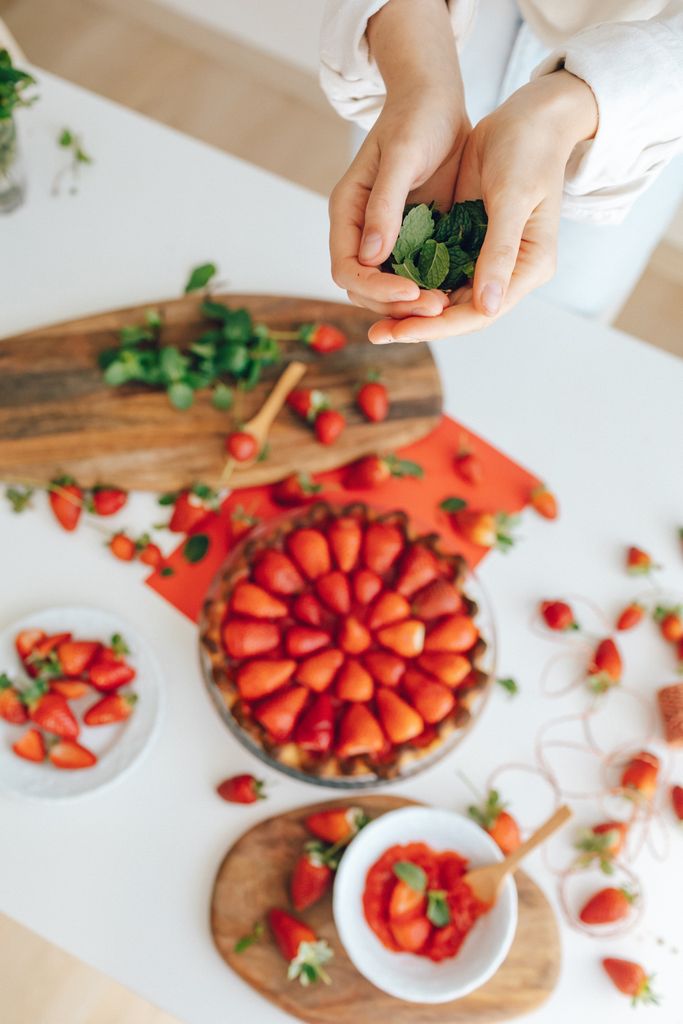 Top view of a delicious strawberry tart with fresh mint, ready for serving. Perfect for food photography.